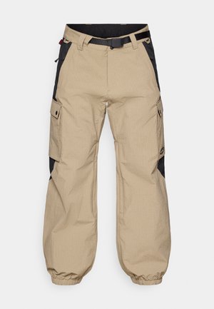 Beige Cargo-Hosen mit Karomuster, schwarzen Seitenteilen, verstellbarem Gürtel und elastischen Bündchen. Mit mehreren Taschen an den Seiten.