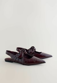 Mörk vinröda spetsiga slingback-lägenheter med en knuten rosett och glansig, texturerad läderfinish.