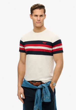 Men's short-sleeve t-shirt in light beige with horizontal navy and red stripes. Features a crew neckline and embroidered logo. Casual denim shirt tied at the waist.