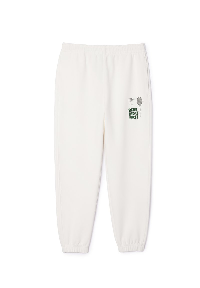 Pantalon de jogging blanc en tissu doux, doté d'une taille élastique et de poignets. Texte imprimé et graphique sur la jambe avant gauche.