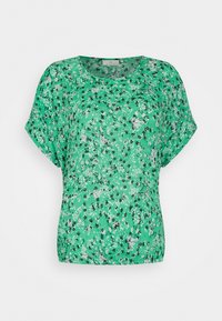 Top de manga corta verde con un corte holgado. Presenta patrones de flores blancas y negras sobre una tela texturizada y ligera. Cuello redondeado.