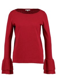 Pull rouge à manches longues avec encolure bateau et poignets à volants superposés, fabriqué en tissu tricoté doux, présenté sur un fond blanc.
