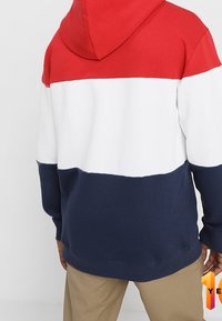 Felpa con cappuccio caratterizzata da righe orizzontali rosse, bianche e blu navy. Realizzata in misto cotone con una texture morbida e polsini a costine.