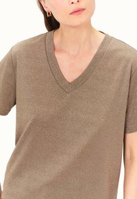 V-Ausschnitt T-Shirt aus metallisch bronzefarbenem Stoff, mit kurzen Ärmeln und einer weichen, strukturierten Oberfläche, im lässigen Schnitt.