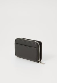 Portafoglio in pelle nera con chiusura a zip, texture liscia, uno slot frontale per carte e accessori in argento. Forma rettangolare compatta.
