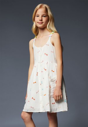 Robe blanche avec des motifs de nœuds multicolores, devant à boutons et poches. Présente des bretelles fines avec des accents de nœuds pastel. Tissu texturé.