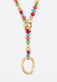 Colorful beaded necklace with various shaped stones in red, green, blue, and peach, featuring a gold oval pendant and black accents.