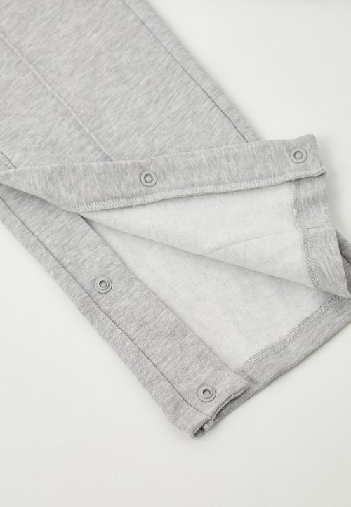 Pantalons en tissu coton gris avec une doublure intérieure douce, dotés de boutons-pression le long du bas et d'un design simple.