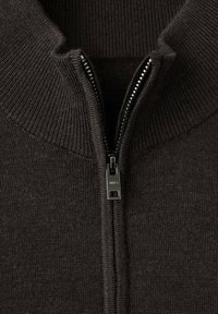 Schwarzer Zip-Up-Pullover mit geripptem Kragen und Struktur. Verfügt über einen Metallreißverschluss mit Zipper, der das klare Design und das Material betont.