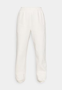 Krämfärgade sweatpants med elastisk midjeband och avslutade anklar. Tillverkade av mjukt tyg, med sidofickor och en diskret logotyp.