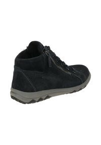 Bottes chelsea en cuir suédé noir avec une surface texturée, dotées d'une fermeture éclair latérale, d'un devant lacé et d'une semelle en caoutchouc grise avec un motif en zigzag.