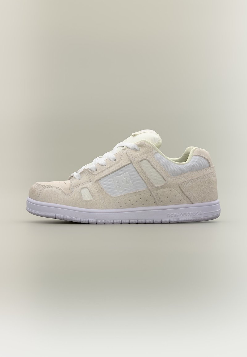 Χαμηλά μπεζ και λευκά αθλητικά παπούτσια με λευκά κορδόνια, διάτρητα πλευρικά πάνελ και λευκή σόλα με το λογότυπο της DC Shoes στη πλευρά και τη φτέρνα.