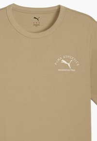 Tanelkleurige T-shirt met korte mouwen van zachte katoen en een ronde hals. Voorzien van een witte opdruk met het logo "PUMA ATHLETICS opgericht 1948."
