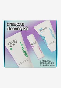 Kit de nettoyage Breakout avec trois produits : gel nettoyant moussant, booster et gelée aquatique, dans des couleurs blanches et pastel douces, avec un étiquetage clair.