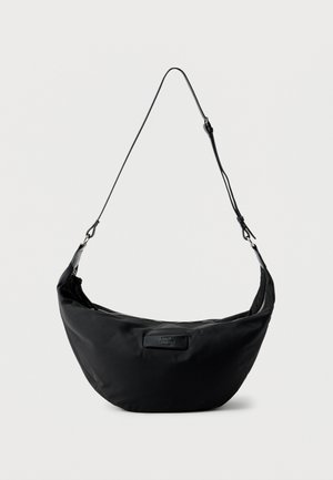 Zwarte schoudertas in halvemaanvorm met verstelbare riem en ritssluiting bovenaan, met een klein rechthoekig logoplaatje aan de voorkant.