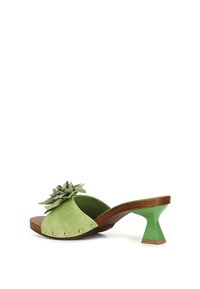 Grønne suede mules med blomsteraccent, rund tå, sølvnitter langs kanten, træmidtesål og en unik triangulær grøn hæl.