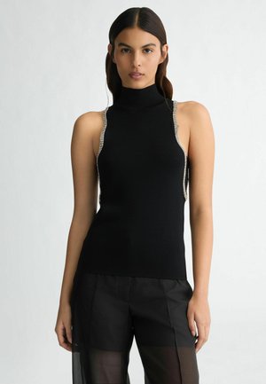 Black sleeveless turtleneck top with a fitted design, featuring silver accents along the shoulders. Fabric appears soft and textured.