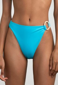 Slip bikini alta turchese con dettagli arricciati e anello di legno in vita. Tessuto dalla consistenza liscia.