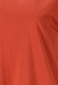 Rød bomulds t-shirt med en glat tekstur. Har en klassisk rund hals og korte ærmer. Materialet fremstår blødt og åndbart.