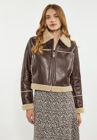 Brun læder cropped jakke med shearling krave og manchetter, med lynlås foran, nitter og cremefarvet shearling kant.