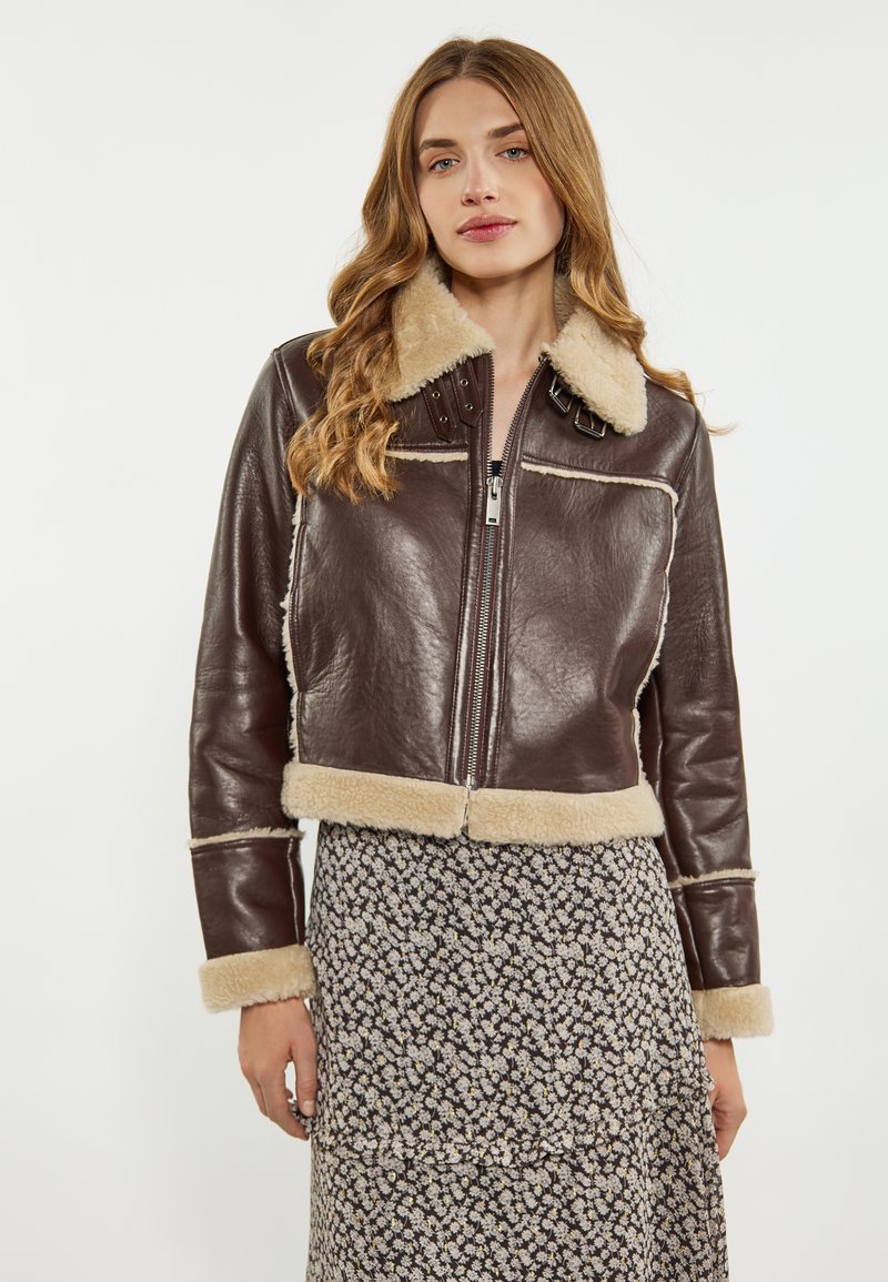Brun læder cropped jakke med shearling krave og manchetter, med lynlås foran, nitter og cremefarvet shearling kant.