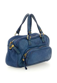 Borsa a mano in pelle blu con due manici, chiusure con zip dorate e una tasca esterna con zip su uno sfondo bianco.