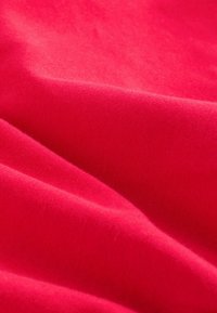Czerwony materiał o miękkiej teksturze, wykazujący gładki wzór i delikatne fałdy, prezentujący bogaty, intensywny odcień bez widocznych wzorów czy akcentów.
