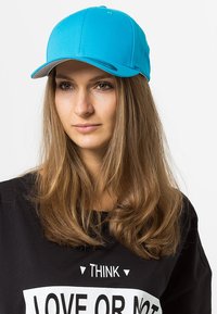 Turquoise baseball cap with a structured crown, curved visor, and contrasting white underside. Cotton material with a smooth texture.