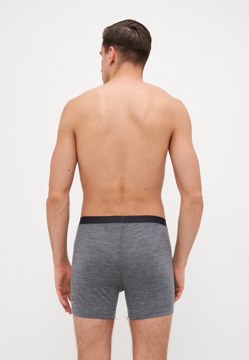 Γκρι βαμβακερό σορτσάκι μποξέρ με σκούρα ζώνη, υφασμάτινη υφή, εφαρμοστή σχεδίαση και χωρίς ορατά σχέδια ή λογότυπα.