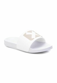 Chanclas blancas de rubber suave, con un logotipo beige de gran tamaño en la correa y una suela plana y flexible.