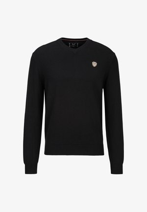 Zwarte v-hals trui gemaakt van gebreide stof, met lange mouwen en een geribde zoom. Een klein embleem is geplaatst op de linkerborst.