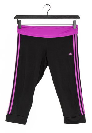 Czarne legginsy Adidas o kroju 7/8 z fioletowym paskiem w talii i bocznymi paskami, wiszące na czarnym wieszaku na białym tle.