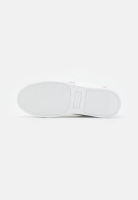 White sneaker sole with textured rubber, featuring a pink logo, rounded edges, and wavy pattern. Flat design suitable for casual wear.
