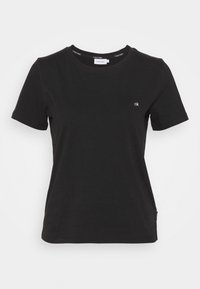 Czarna koszulka z krótkim rękawem marki Calvin Klein z małym białym logo "ck" po lewej stronie klatki piersiowej i okrągłym dekoltem.
