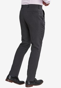 Pantaloni gri cărbune dintr-un material combinat, cu croi slim, buzunar posterior cu închidere cu buton și textură netedă.
