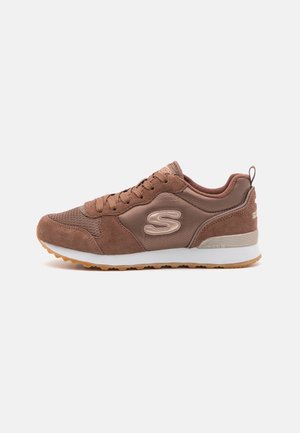 Brun Skechers sneaker med ruskind og mesh paneler, snørelukning, hvid mellemsål og ydersål i gummi, vist på en enkel hvid baggrund.