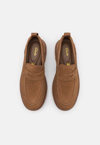 Brune lær slip-on sko med rund tå, dobbelt elastisk detaljer og teksturert overflate. Har en logo på sålen.