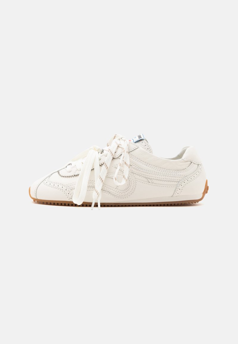 Basket en cuir blanc avec semelle marron et lacets noués, vue de profil sur fond clair uni.