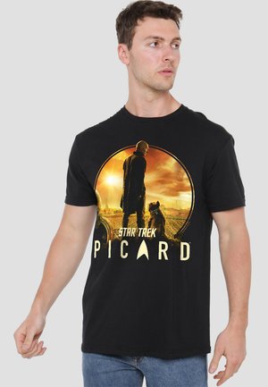 Schwarzes Baumwoll-T-Shirt mit einem kreisförmigen Grafikdesign eines Charakters mit einem Hund vor einem Sonnenuntergang, mit dem Text "Star Trek Picard" darunter.