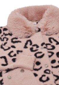 Rosa konstpälsjacka med svart leopardmönster, med en dubbelknäppt design och stor pälskrage. Silverknappar och mjuk textur.