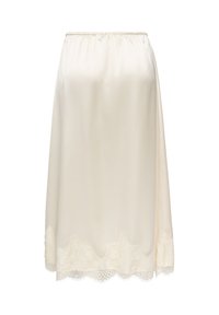 Jupe-culotte crème longueur genou avec ceinture élastique et bordure en dentelle festonnée le long de l'ourlet.