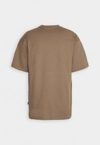 T-shirt en coton marron uni à manches courtes, montré de dos sur fond blanc.