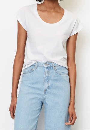 Hvid T-shirt med korte ærmer og rund halsudskæring kombineret med lyseblå, høj taljede jeans med afslappet pasform og denimtekstur.