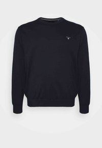 Czarny sweter wykonany z bawełny, z okrągłym dekoltem, długimi rękawami i ściągaczami na mankietach z małym logo na piersi.