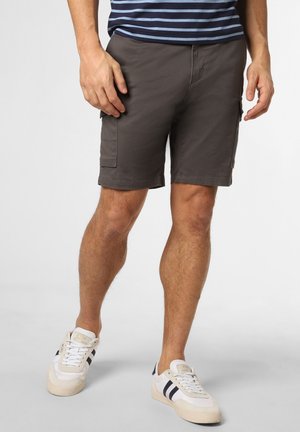 Graue Cargo-Shorts aus Baumwolle, mit Seitentaschen, geradem Schnitt und hüftlanger Länge. Kombiniert mit weißen Sneakers.