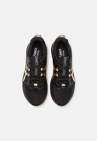 Scarpe sportive nere con dettagli arancioni e tessuto in rete. Presentano una soletta ammortizzata e lacci, con il logo ASICS sulla linguetta.