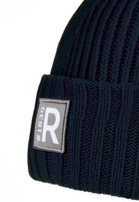 Navy blue ribbed knit beanie with a folded cuff featuring a gray rectangular patch embossed with "#1839" and a large white "R".