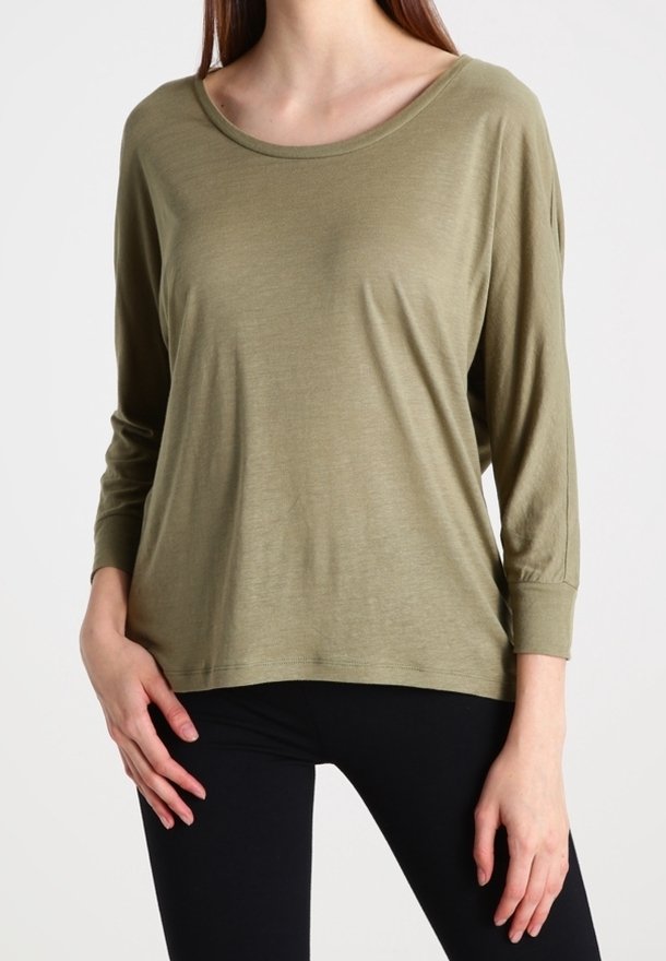Olivově zelený dlouhý rukáv top z měkké, lehké látky. Má široký výstřih a volný střih s manžetami na rukávech.