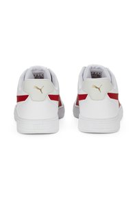 Buty sportowe Puma z zewnętrzną częścią wykonaną z białego syntetyku, czerwonymi akcentami i złotym logo na pięcie. Posiadają teksturowaną podeszwę i wyściełany kołnierz dla komfortu.