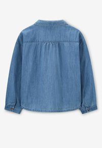 Light blue denim shirt with a collared neck, long sleeves, and gathered detail at the back. Button accents on the cuffs. Smooth texture.